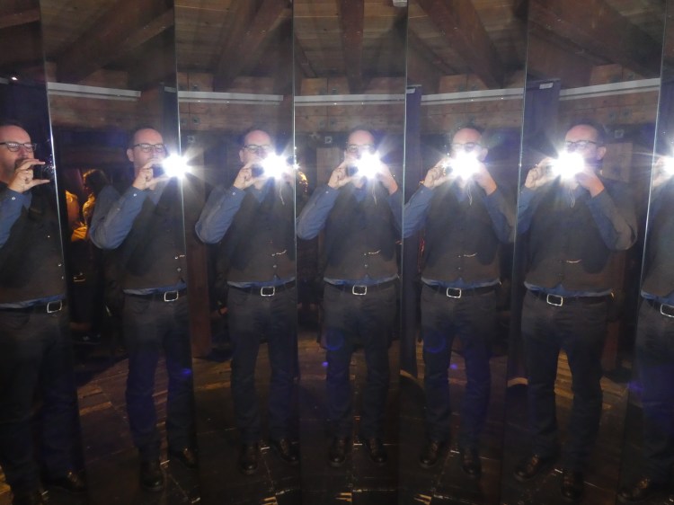 Multiple images of a man taking a photograph in a set of mirrors 